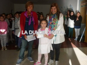 Las docentes Laura Burgos y  Elisabeth Canosa entregando los diplomas a los alumnos.